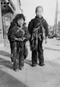Children of Kamoi. The child on the left is carrying her sibling on her back.